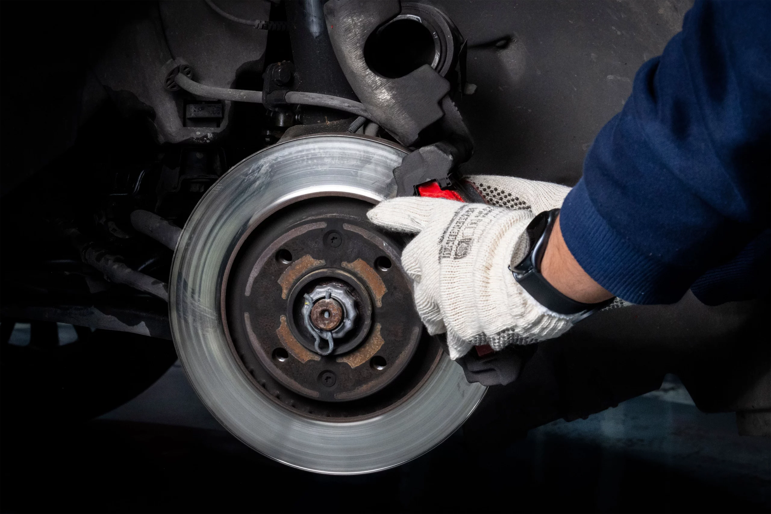 Mechanic performing brake maintenance in a workshop