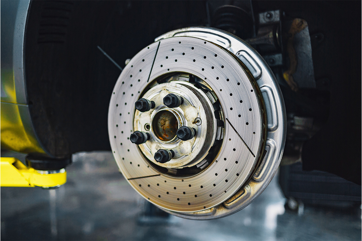 Close-up of a brake caliper and rotor during inspection