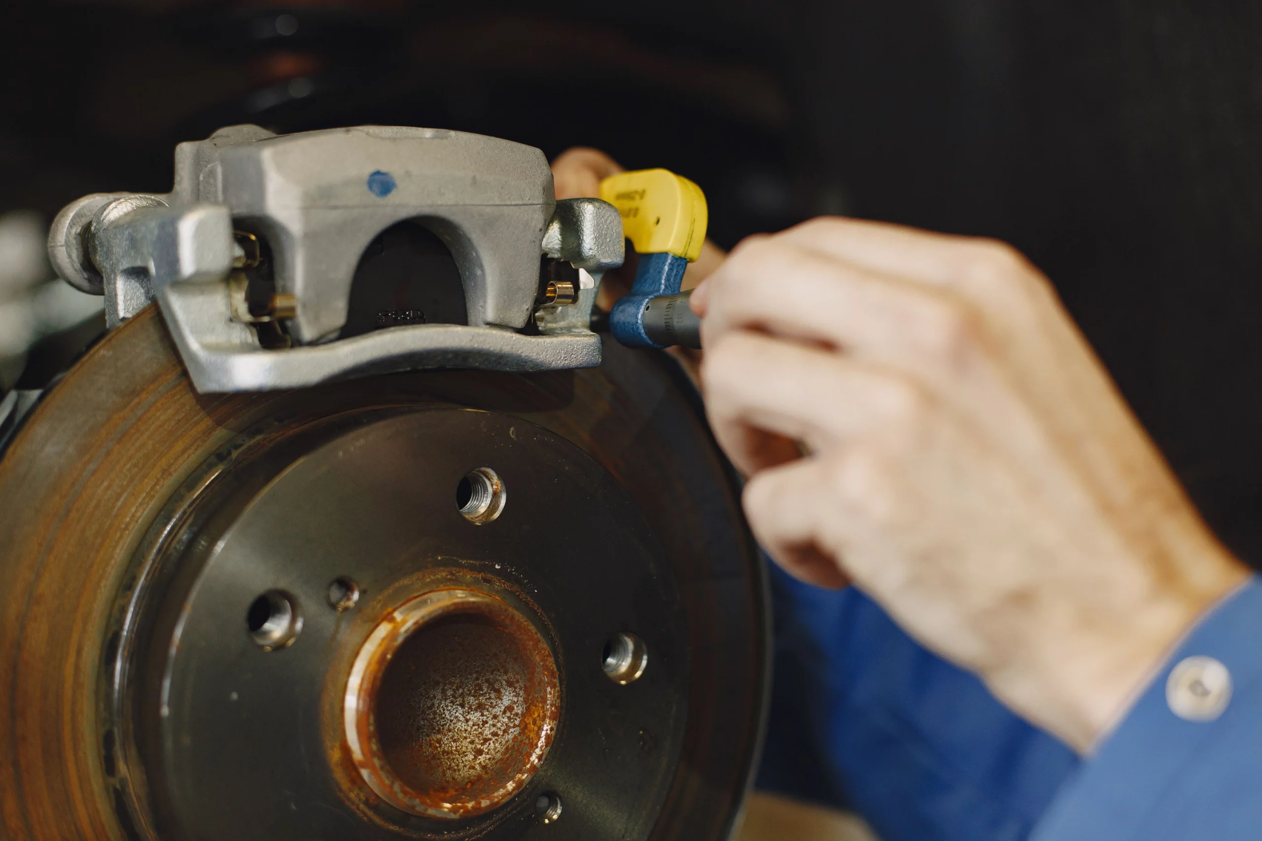 Mechanic inspecting brake components under the hood