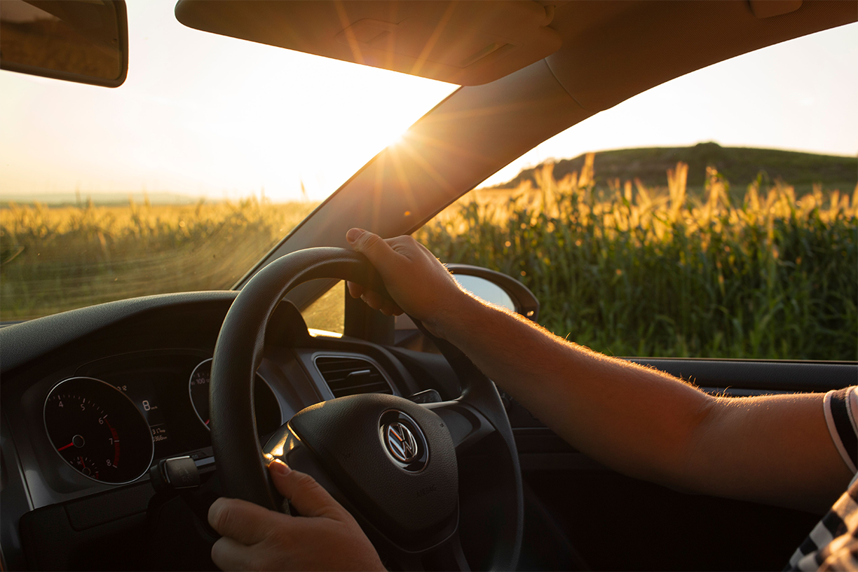 Driver enjoying a summer road trip after a vehicle maintenance check