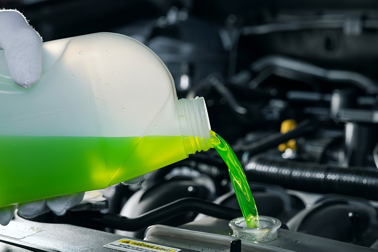 Fresh engine coolant being poured into a vehicle cooling system.