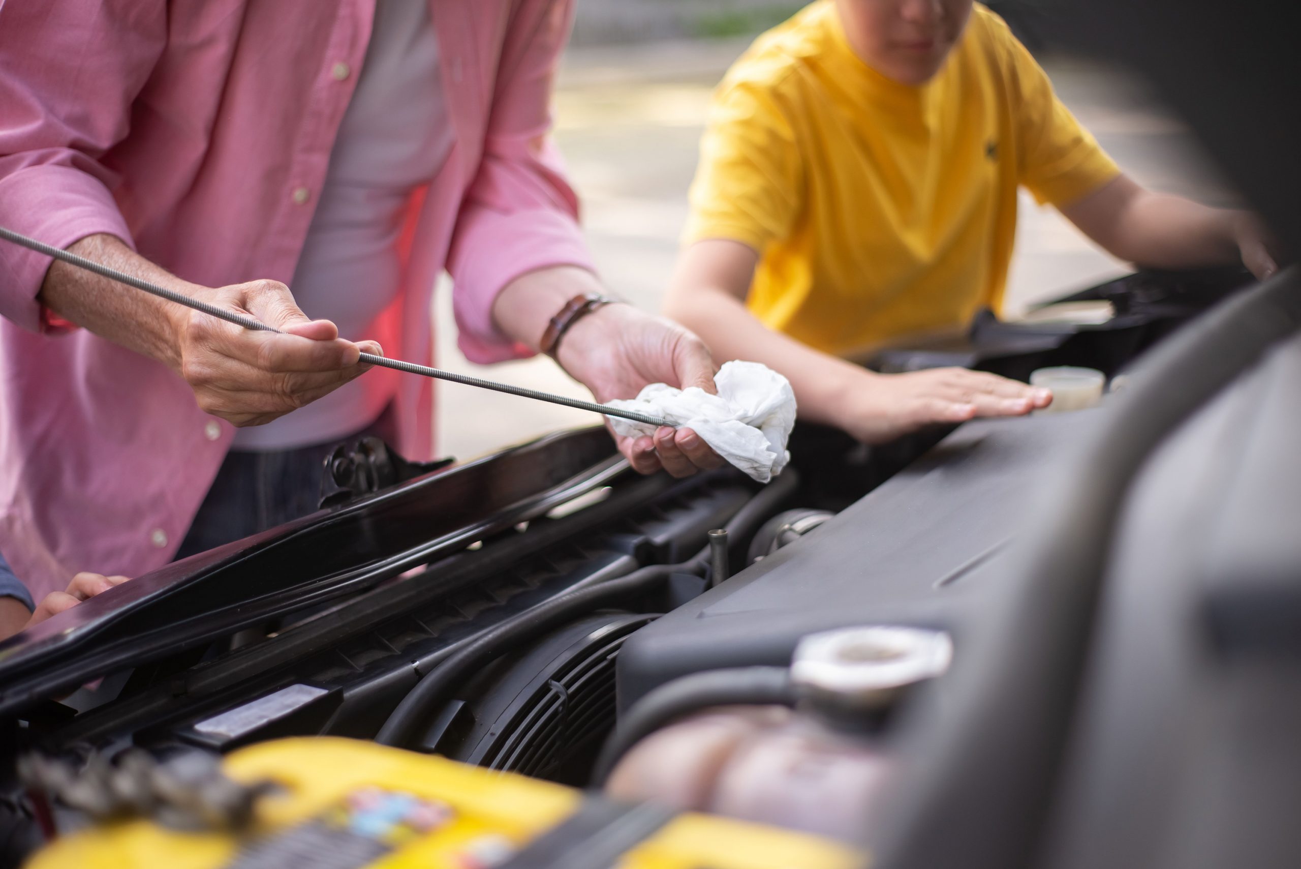Technician checking engine oil dipstick