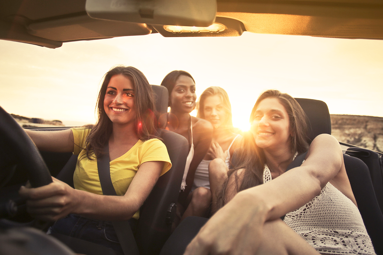 Family enjoying a safe summer road trip in their vehicle.