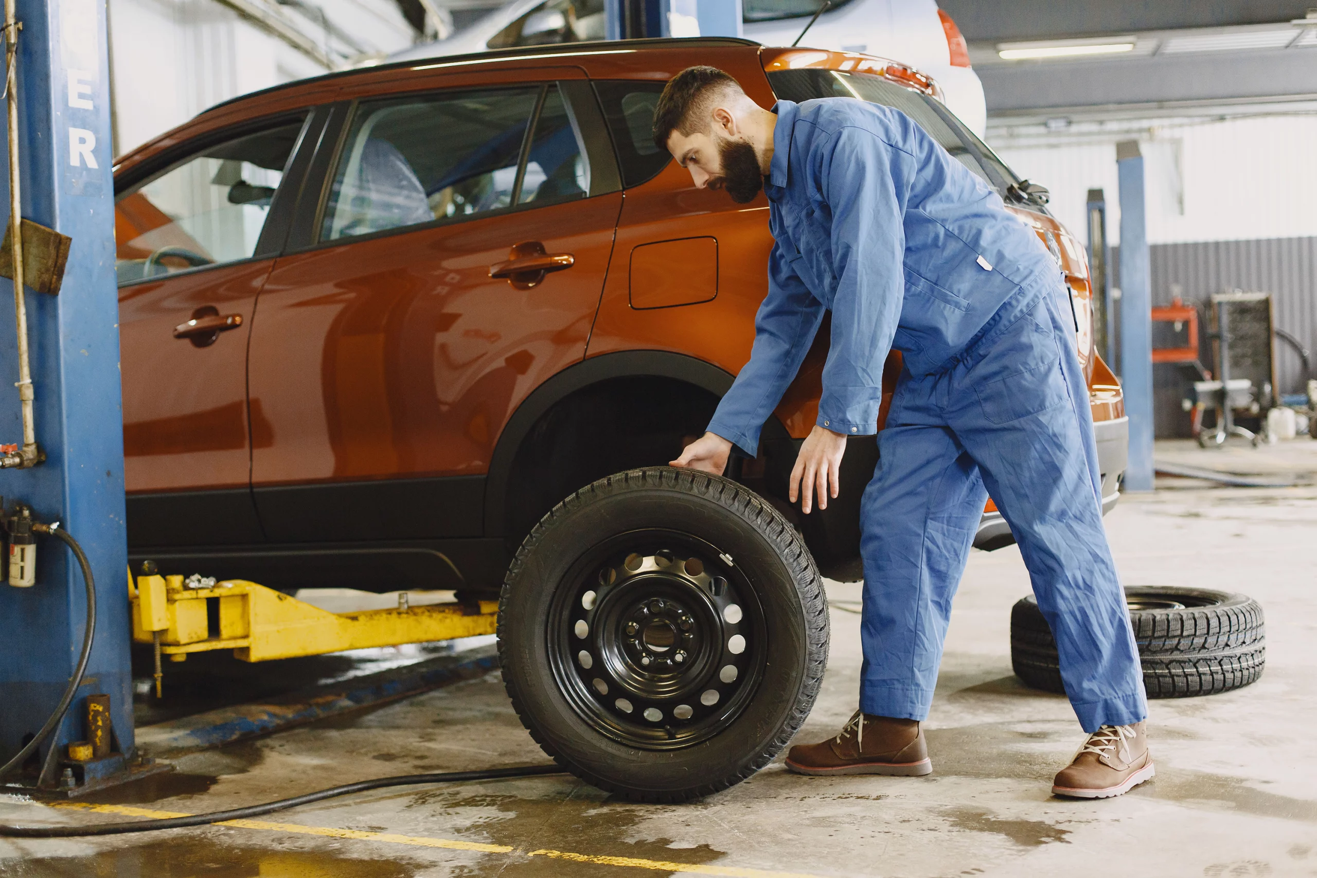 Technician checking tire pressure and wear