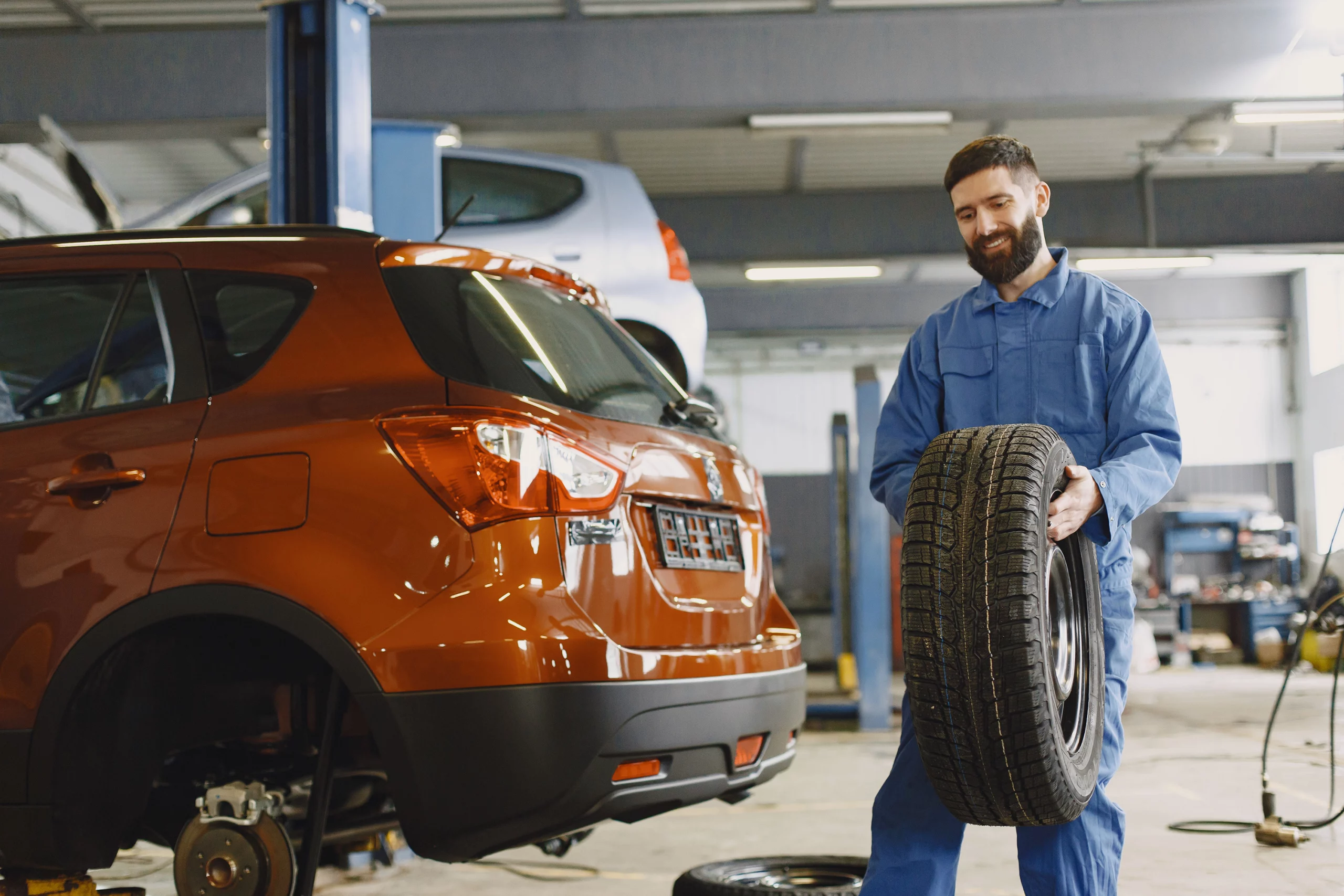 Mechanic holding a black tire during a rotation service