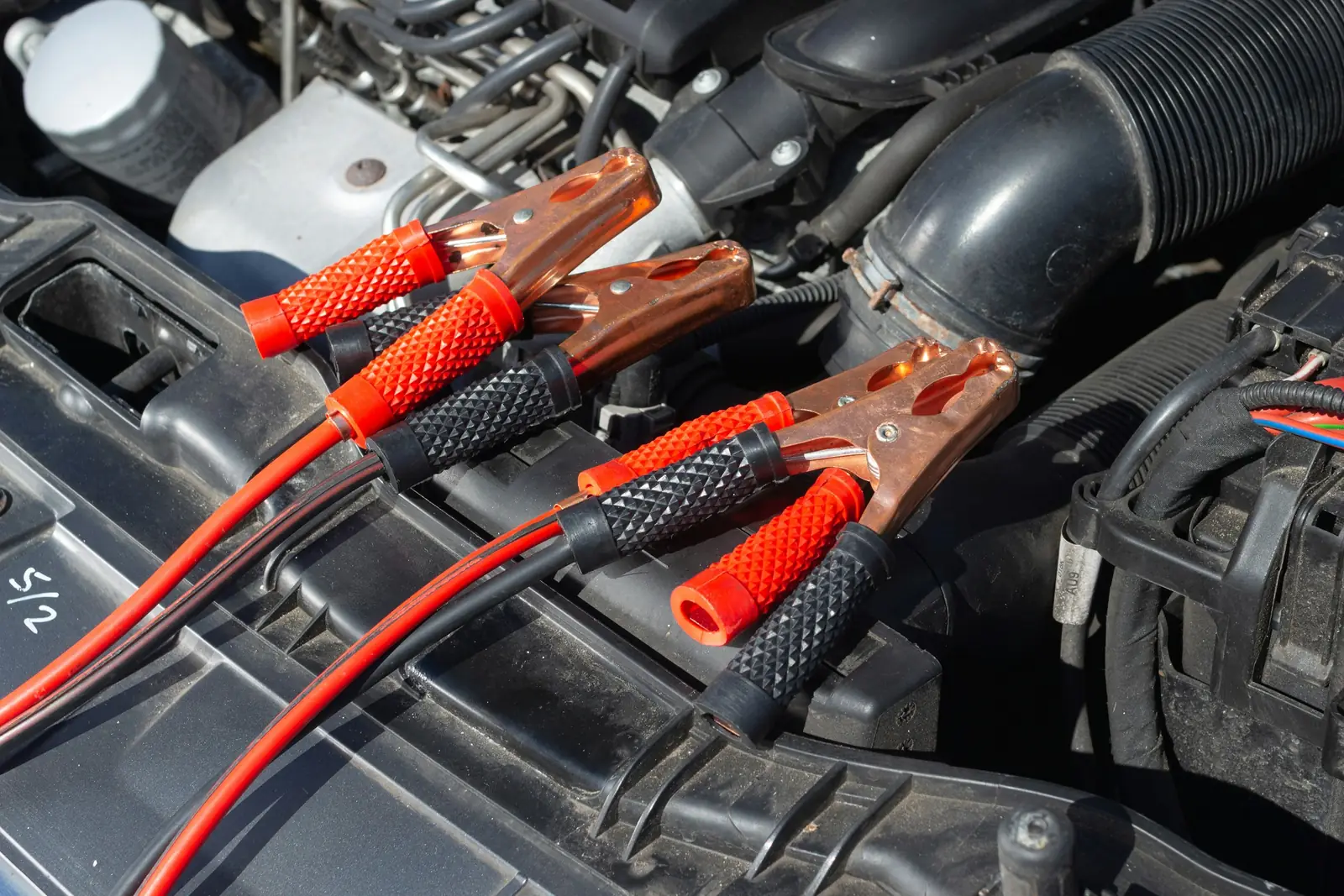 Jumper cable clamps connected to a car battery